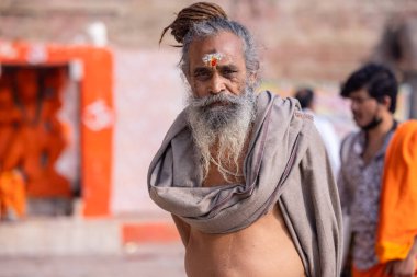 Varanasi, Uttar Pradesh, Hindistan - 20 Kasım 2022: Varanasi şehrinde geleneksel elbise içinde nehir çetelerinin yakınlarındaki ghat üzerinde tanımlanamayan Hint kutsal sadhu erkek portresi.