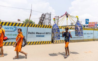 Gaziabad, Uttar Pradesh, Hindistan - 24 Temmuz 2022: Hindu hacı portresi Muson zamanında Lord Shiv 'e ibadet etmek ve nehir çetelerinin kutsal suyunu taşımak için çıplak ayakla kanwar yatra yapıyor.