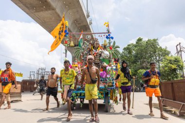 Gaziabad, Uttar Pradesh, Hindistan - 24 Temmuz 2022: Hindu hacı portresi Muson zamanında Lord Shiv 'e ibadet etmek ve nehir çetelerinin kutsal suyunu taşımak için çıplak ayakla kanwar yatra yapıyor.