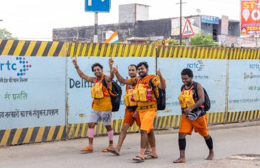 Gaziabad, Uttar Pradesh, Hindistan - 24 Temmuz 2022: Hindu hacı portresi Muson zamanında Lord Shiv 'e ibadet etmek ve nehir çetelerinin kutsal suyunu taşımak için çıplak ayakla kanwar yatra yapıyor.