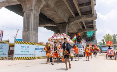 Gaziabad, Uttar Pradesh, Hindistan - 24 Temmuz 2022: Hindu hacı portresi Muson zamanında Lord Shiv 'e ibadet etmek ve nehir çetelerinin kutsal suyunu taşımak için çıplak ayakla kanwar yatra yapıyor.