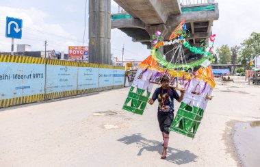 Gaziabad, Uttar Pradesh, Hindistan - 24 Temmuz 2022: Hindu hacı portresi Muson zamanında Lord Shiv 'e ibadet etmek ve nehir çetelerinin kutsal suyunu taşımak için çıplak ayakla kanwar yatra yapıyor.