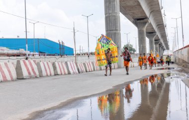 Gaziabad, Uttar Pradesh, Hindistan - 24 Temmuz 2022: Hindu hacı portresi Muson zamanında Lord Shiv 'e ibadet etmek ve nehir çetelerinin kutsal suyunu taşımak için çıplak ayakla kanwar yatra yapıyor.