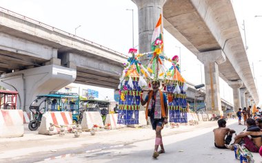 Ghaziabad, Uttar Pradesh, India - July 24 2022: Portrait of hindu pilgrim performing kanwar yatra barefoot to worship lord shiv during monsoon time and carrying holy water of river ganges. clipart