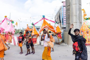 Gaziabad, Uttar Pradesh, Hindistan - 24 Temmuz 2022: Hindu hacı portresi Muson zamanında Lord Shiv 'e ibadet etmek ve nehir çetelerinin kutsal suyunu taşımak için çıplak ayakla kanwar yatra yapıyor.