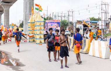 Gaziabad, Uttar Pradesh, Hindistan - 24 Temmuz 2022: Hindu hacı portresi Muson zamanında Lord Shiv 'e ibadet etmek ve nehir çetelerinin kutsal suyunu taşımak için çıplak ayakla kanwar yatra yapıyor.