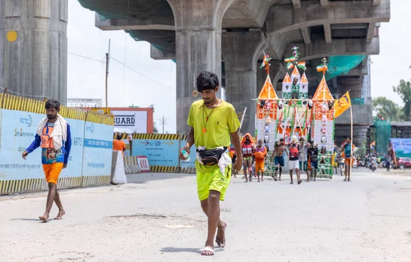 stock image Ghaziabad, Uttar Pradesh, India - July 24 2022: Portrait of hindu pilgrim performing kanwar yatra barefoot to worship lord shiv during monsoon time and carrying holy water of river ganges.