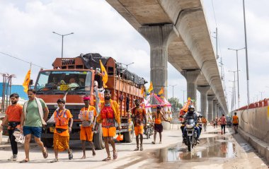 Gaziabad, Uttar Pradesh, Hindistan - 24 Temmuz 2022: Hindu hacı portresi Muson zamanında Lord Shiv 'e ibadet etmek ve nehir çetelerinin kutsal suyunu taşımak için çıplak ayakla kanwar yatra yapıyor.
