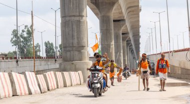 Gaziabad, Uttar Pradesh, Hindistan - 24 Temmuz 2022: Hindu hacı portresi Muson zamanında Lord Shiv 'e ibadet etmek ve nehir çetelerinin kutsal suyunu taşımak için çıplak ayakla kanwar yatra yapıyor.