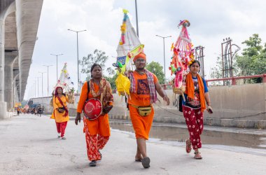 Gaziabad, Uttar Pradesh, Hindistan - 24 Temmuz 2022: Hindu hacı portresi Muson zamanında Lord Shiv 'e ibadet etmek ve nehir çetelerinin kutsal suyunu taşımak için çıplak ayakla kanwar yatra yapıyor.