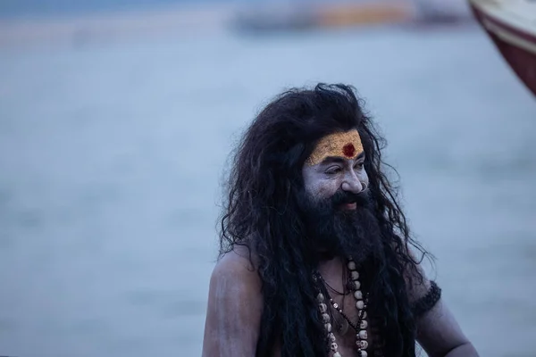 stock image Varanasi, Uttar Pradesh, India - November 20 2022: Portrait of Unidentified Indian male actor as naga sadhu with ask on his face and body sitting on wooden boat in river ganges at varanasi.