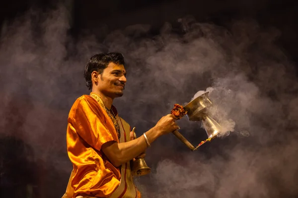 stock image Varanasi, Uttar Pradesh, India - November 20 2022: Ganga aarti, Portrait of young priest performing holy river ganges evening aarti at dashashwamedh ghat in traditional dress with hindu rituals.