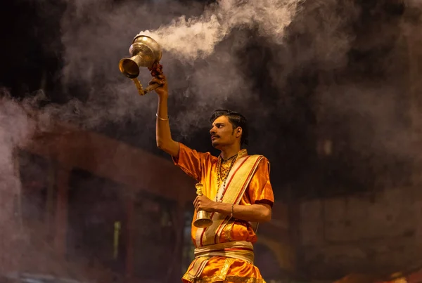 stock image Varanasi, Uttar Pradesh, India - November 20 2022: Ganga aarti, Portrait of young priest performing holy river ganges evening aarti at dashashwamedh ghat in traditional dress with hindu rituals.
