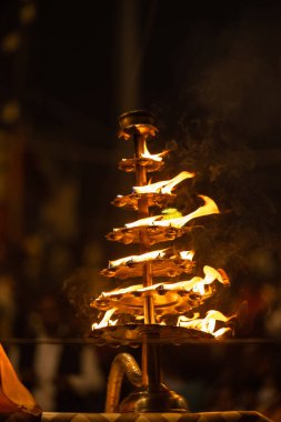Varanasi, Uttar Pradesh, Hindistan - 20 Kasım 2022: Ganga aarti, Dashashwamedh ghat 'ında geleneksel Hint ayinleriyle akşam üzeri genç rahibin kutsal nehir çetelerini sergilediği portre.