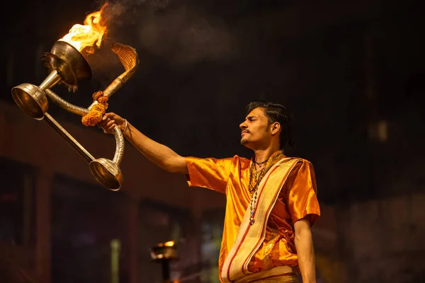 stock image Varanasi, Uttar Pradesh, India - November 20 2022: Ganga aarti, Portrait of young priest performing holy river ganges evening aarti at dashashwamedh ghat in traditional dress with hindu rituals.