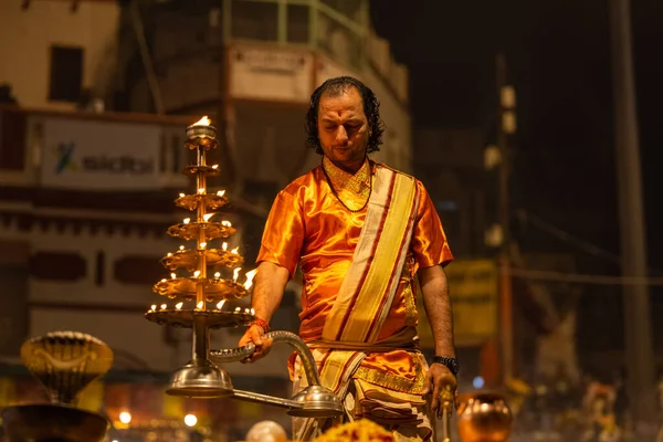 stock image Varanasi, Uttar Pradesh, India - November 20 2022: Ganga aarti, Portrait of young priest performing holy river ganges evening aarti at dashashwamedh ghat in traditional dress with hindu rituals.