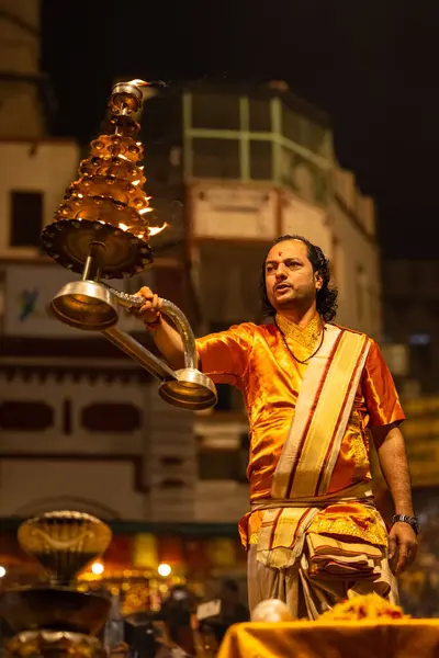 stock image Varanasi, Uttar Pradesh, India - November 20 2022: Ganga aarti, Portrait of young priest performing holy river ganges evening aarti at dashashwamedh ghat in traditional dress with hindu rituals.