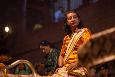 Varanasi, Uttar Pradesh, Hindistan - 20 Kasım 2022: Ganga aarti, Dashashwamedh ghat 'ında geleneksel Hint ayinleriyle akşam üzeri genç rahibin kutsal nehir çetelerini sergilediği portre.