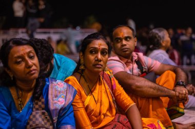 Varanasi, Uttar Pradesh, Hindistan - 20 Kasım 2022: Ganga aarti, Dashashwamedh ghat 'ında geleneksel Hint ayinleriyle akşam üzeri genç rahibin kutsal nehir çetelerini sergilediği portre.