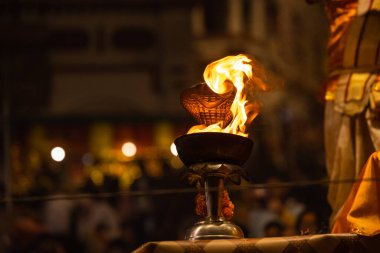 Varanasi, Uttar Pradesh, Hindistan - 20 Kasım 2022: Ganga aarti, Dashashwamedh ghat 'ında geleneksel Hint ayinleriyle akşam üzeri genç rahibin kutsal nehir çetelerini sergilediği portre.
