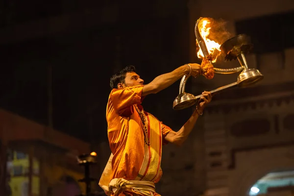 Stock image Varanasi, Uttar Pradesh, India - November 20 2022: Ganga aarti, Portrait of young priest performing holy river ganges evening aarti at dashashwamedh ghat in traditional dress with hindu rituals.