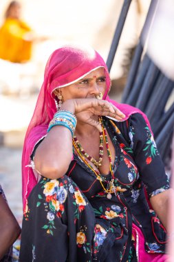 Puşkar, Rajasthan, Hindistan - Kasım 05 2022: Puşkar Fuarı, Rajasthan 'lı kadın portresi Renkli geleneksel elbise ve başörtüsü.