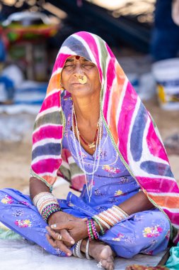 Puşkar, Rajasthan, Hindistan - Kasım 05 2022: Puşkar Fuarı, Rajasthan 'lı kadın portresi Renkli geleneksel elbise ve başörtüsü.