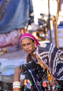 Puşkar, Rajasthan, Hindistan - Kasım 05 2022: Puşkar Fuarı, Rajasthan 'lı kadın portresi Renkli geleneksel elbise ve başörtüsü.