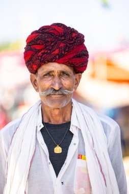 Puşkar, Rajasthan, Hindistan - Kasım 05 2022: Puşkar Fuarı, Rajasthani 'nin beyaz geleneksel elbisesi ve renkli sarıklı portresi.