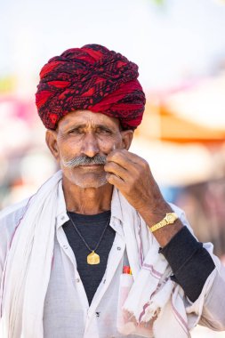 Puşkar, Rajasthan, Hindistan - Kasım 05 2022: Puşkar Fuarı, Rajasthani 'nin beyaz geleneksel elbisesi ve renkli sarıklı portresi.