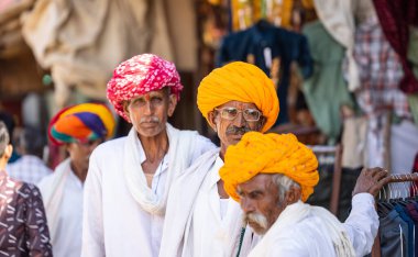 Puşkar, Rajasthan, Hindistan - Kasım 05 2022: Puşkar Fuarı, Rajasthani 'nin beyaz geleneksel elbisesi ve renkli sarıklı portresi. 