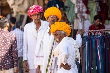 Puşkar, Rajasthan, Hindistan - Kasım 05 2022: Puşkar Fuarı, Rajasthani 'nin beyaz geleneksel elbisesi ve renkli sarıklı portresi. 