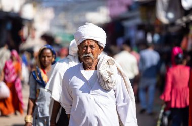 Puşkar, Rajasthan, Hindistan - Kasım 05 2022: Puşkar Fuarı, Rajasthani 'nin beyaz geleneksel elbisesi ve renkli sarıklı portresi.