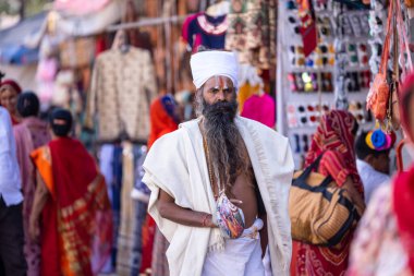 Puşkar, Rajasthan, Hindistan - Kasım 05 2022: Puşkar Fuarı, geleneksel deve fuarı sırasında Pushkar caddesindeki yaşlı bir sadhu babanın portresi.