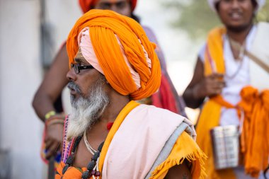 Puşkar, Rajasthan, Hindistan - Kasım 05 2022: Puşkar Fuarı, geleneksel deve fuarı sırasında Pushkar caddesindeki yaşlı bir sadhu babanın portresi.