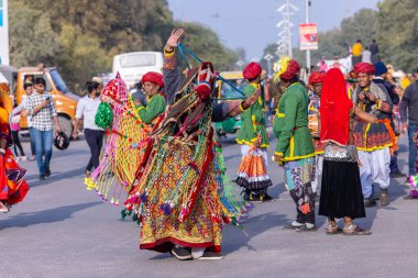 Bikaner, Rajasthan, Hindistan - 13 Ocak 2023: Deve Festivali, Bir Rajasthani erkek sanatçının portresi geçit töreni sırasında geleneksel kıyafetlerle at dansı yapıyor..
