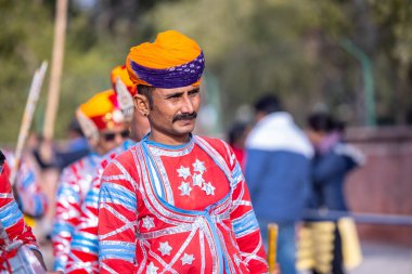 Bikaner, Rajasthan, Hindistan - 13 Ocak 2023: Deve Festivali, geleneksel renkli rajasthani elbisesi giyen renkli türbanlı bir müzik enstrümanı çalan bir Rajasthani erkek sanatçı grubu.