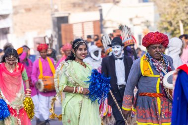 Bikaner, Rajasthan, Hindistan - 13 Ocak 2023: Deve Festivali Bikaner, geleneksel rajasthani elbisesi ve takılarıyla törene katılan bir grup genç kız. Seçici odak.