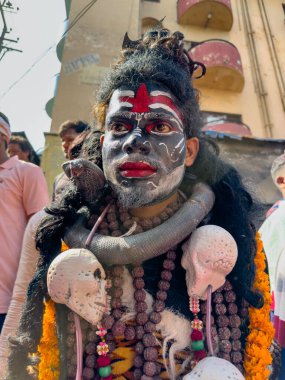 Varanasi, Uttar Pradesh, Hindistan - Mart 03 2023: Masan Holi, Varanasi 'deki Harishchandra ghat' ta düzenlenen Masaj Holi kutlamaları sırasında yüzünü boyayan bir erkek sanatçının portresi..