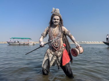 Varanasi, Uttar Pradesh, Hindistan - Mart 03 2023: Masan Holi, Varanasi 'deki Harishchandra ghat' ta düzenlenen Masaj Holi kutlamaları sırasında yüzünü boyayan bir erkek sanatçının portresi..