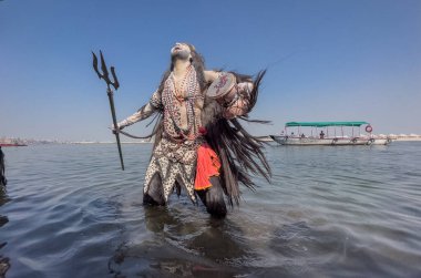 Varanasi, Uttar Pradesh, Hindistan - Mart 03 2023: Masan Holi, Varanasi 'deki Harishchandra ghat' ta düzenlenen Masaj Holi kutlamaları sırasında yüzünü boyayan bir erkek sanatçının portresi..