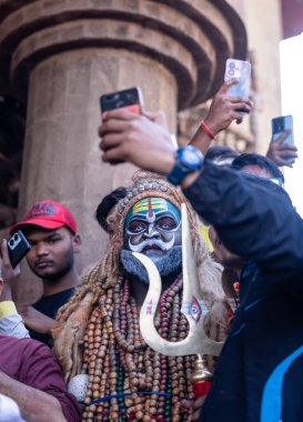 Varanasi, Uttar Pradesh, Hindistan - Mart 03 2023: Masan Holi, Varanasi 'deki Harishchandra ghat' ta düzenlenen Masaj Holi kutlamaları sırasında yüzünü boyayan bir erkek sanatçının portresi..