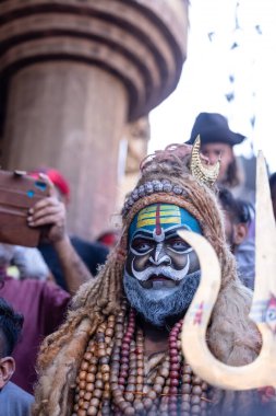Varanasi, Uttar Pradesh, Hindistan - Mart 03 2023: Masan Holi, Varanasi 'deki Harishchandra ghat' ta düzenlenen Masaj Holi kutlamaları sırasında yüzünü boyayan bir erkek sanatçının portresi..