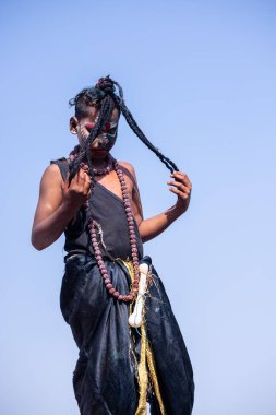 Varanasi, Uttar Pradesh, Hindistan - Mart 03 2023: Masan Holi, Varanasi 'deki Harishchandra ghat' ta düzenlenen Masaj Holi kutlamaları sırasında yüzünü boyayan bir erkek sanatçının portresi..