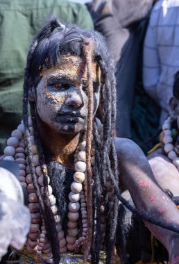 Varanasi, Uttar Pradesh, Hindistan - Mart 03 2023: Masan Holi, Varanasi 'deki Harishchandra ghat' ta düzenlenen Masaj Holi kutlamaları sırasında yüzünü boyayan bir erkek sanatçının portresi..