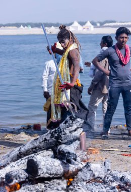 Varanasi, Uttar Pradesh, Hindistan - Mart 03 2023: Masan Holi, Varanasi 'deki Harishchandra ghat' ta düzenlenen Masaj Holi kutlamaları sırasında yüzünü boyayan bir erkek sanatçının portresi..