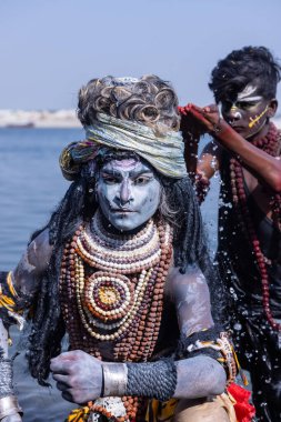 Varanasi, Uttar Pradesh, Hindistan - Mart 03 2023: Masan Holi, Varanasi 'deki Harishchandra ghat' ta düzenlenen Masaj Holi kutlamaları sırasında yüzünü boyayan bir erkek sanatçının portresi..