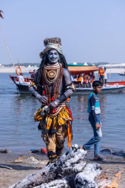 Varanasi, Uttar Pradesh, Hindistan - Mart 03 2023: Masan Holi, Varanasi 'deki Harishchandra ghat' ta düzenlenen Masaj Holi kutlamaları sırasında yüzünü boyayan bir erkek sanatçının portresi..