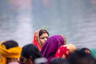 Gaziabad, Uttar Pradesh, Hindistan - 30 Ekim 2022: Chhas Puja, Hintli kadın dindar gün batımında Lord Sun 'a ibadet etmek için nehirde dururken Chhas puja ayini yapıyor..