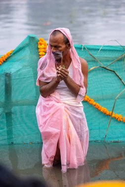 Gaziabad, Uttar Pradesh, Hindistan - 30 Ekim 2022: Chhas Puja, Hintli kadın dindar gün batımında Lord Sun 'a ibadet etmek için nehirde dururken Chhas puja ayini yapıyor..